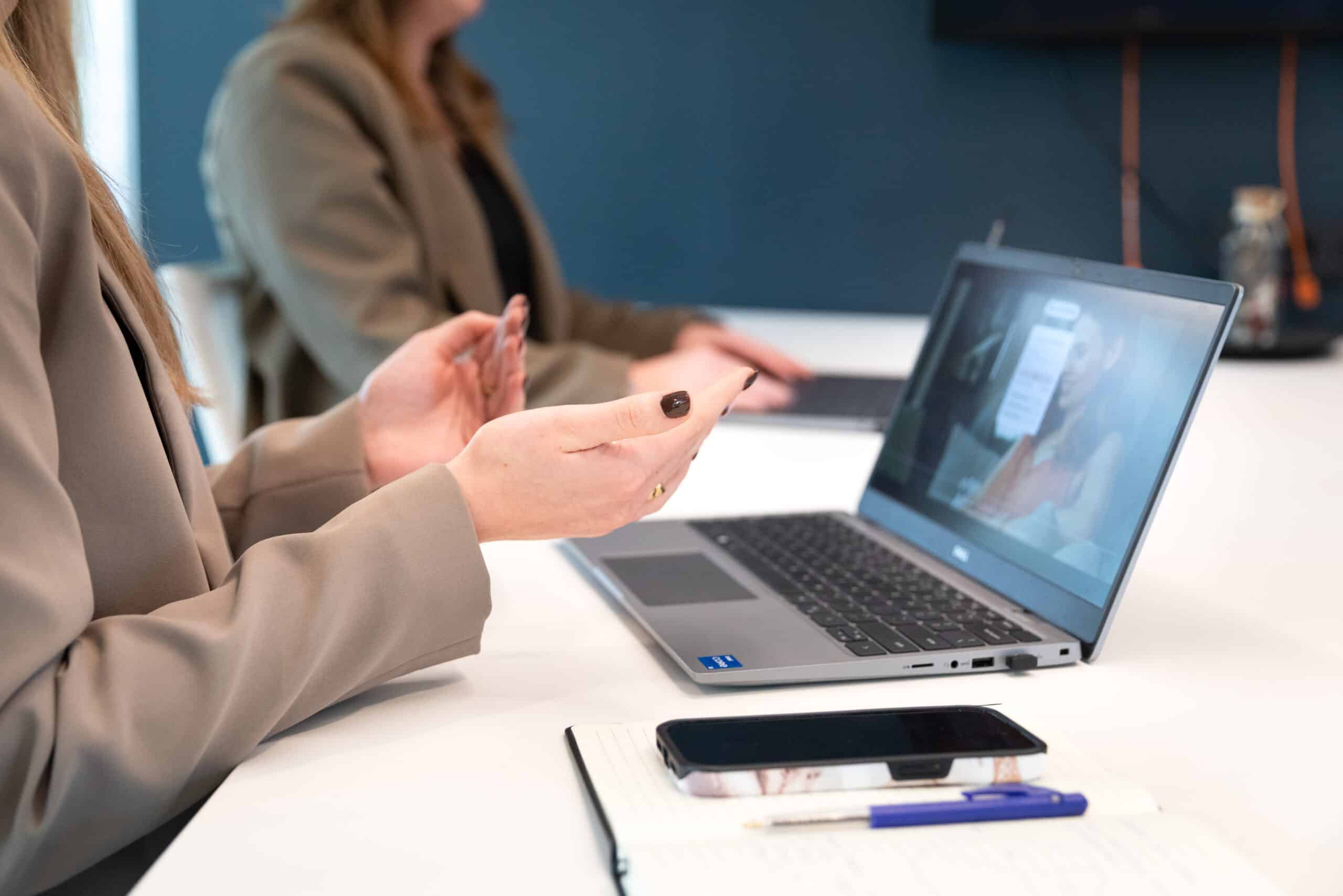 close up of two employees working on their laptops