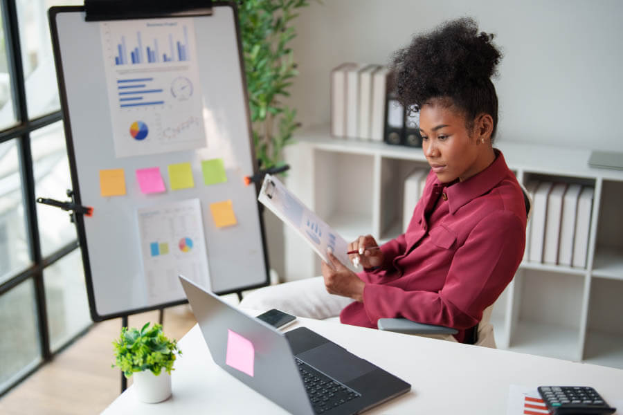 businesswoman analyzing financial data, reviewing statistics and business reports