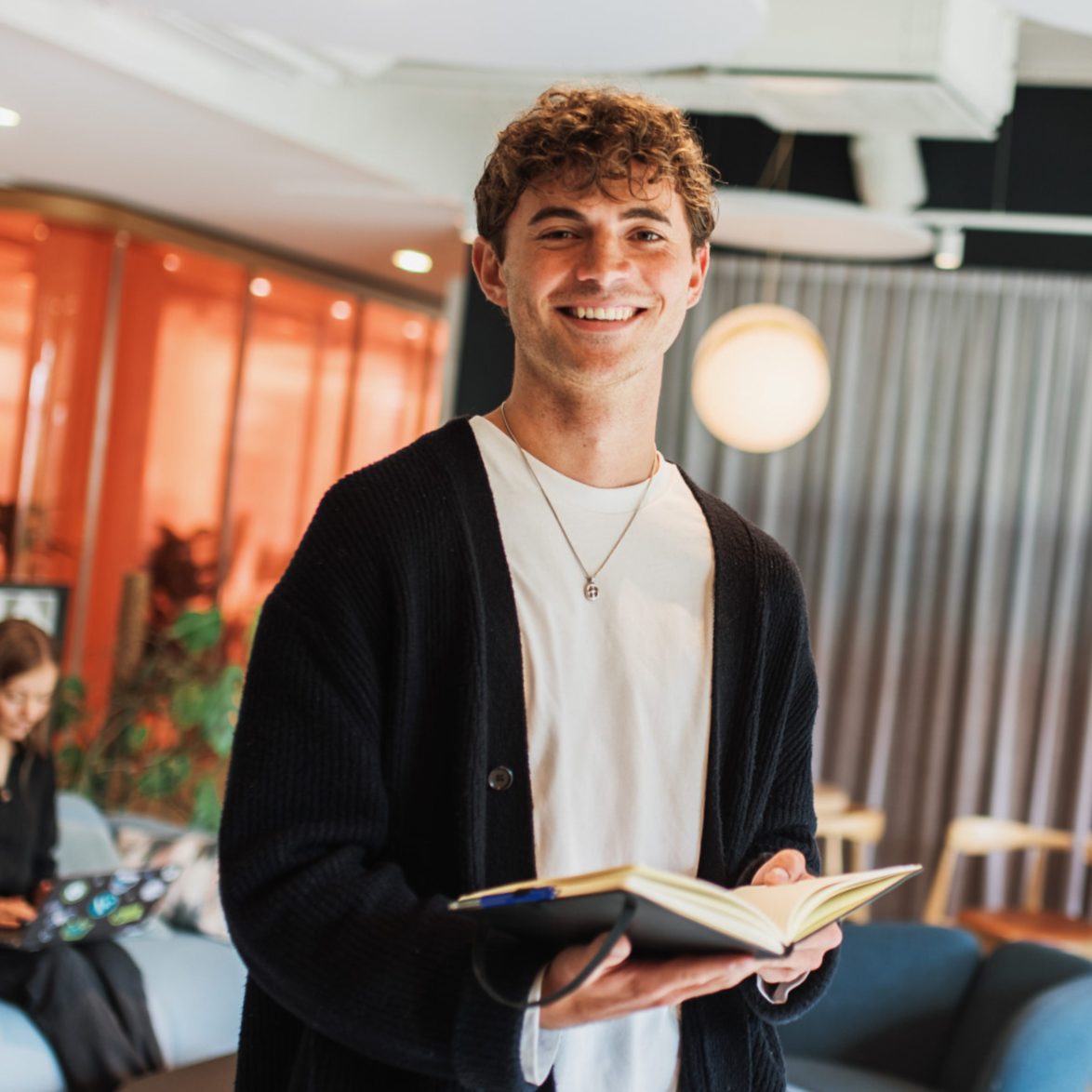 Smiling male employee holding notebook