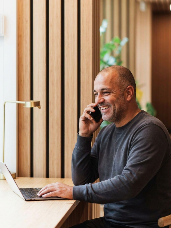 Affärsman som ler på telefonen som validerar och internationell kandidat