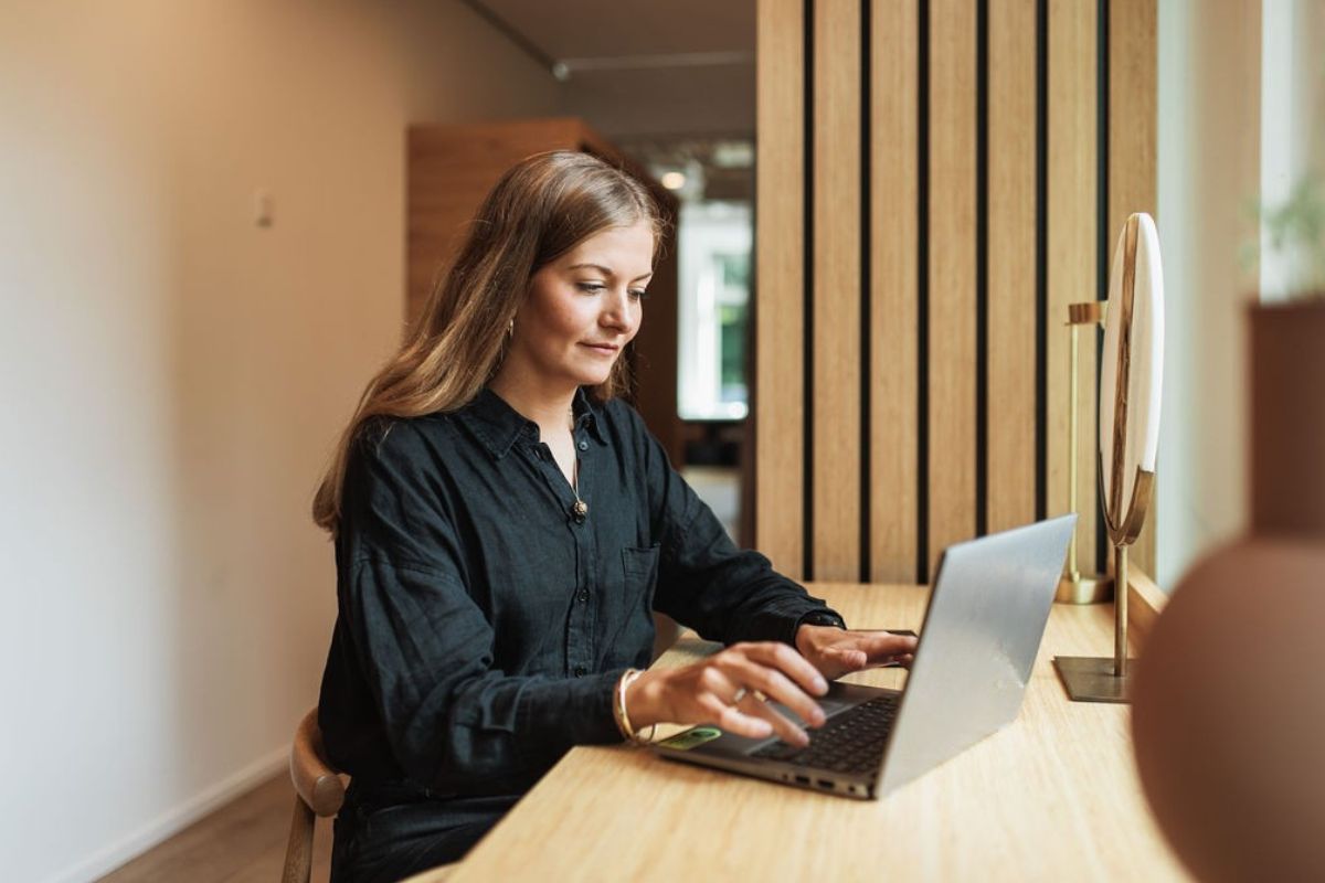 Woman sitting with a laptop reading about background checks in accounting