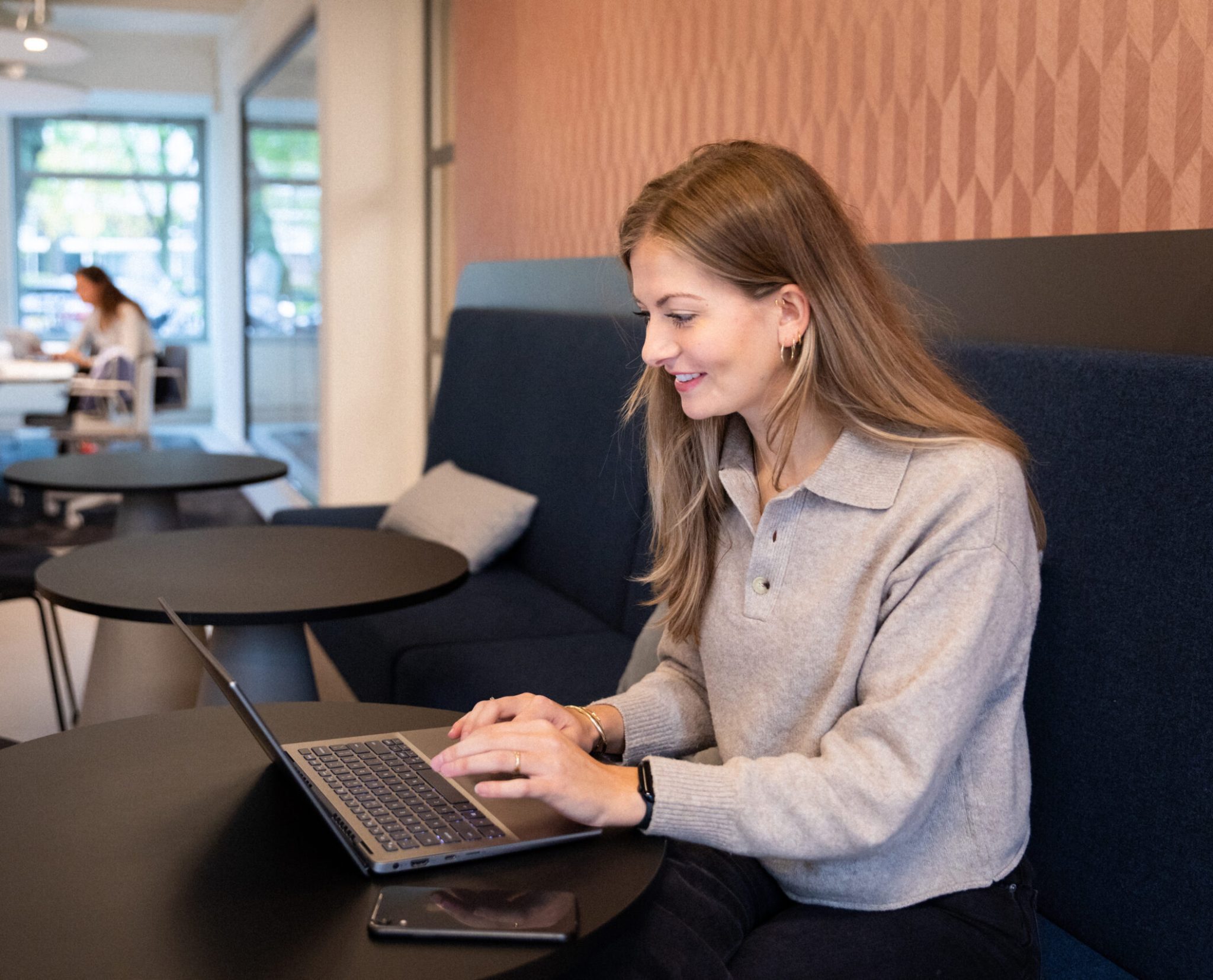 Woman sitting in an office sofa with her laptop