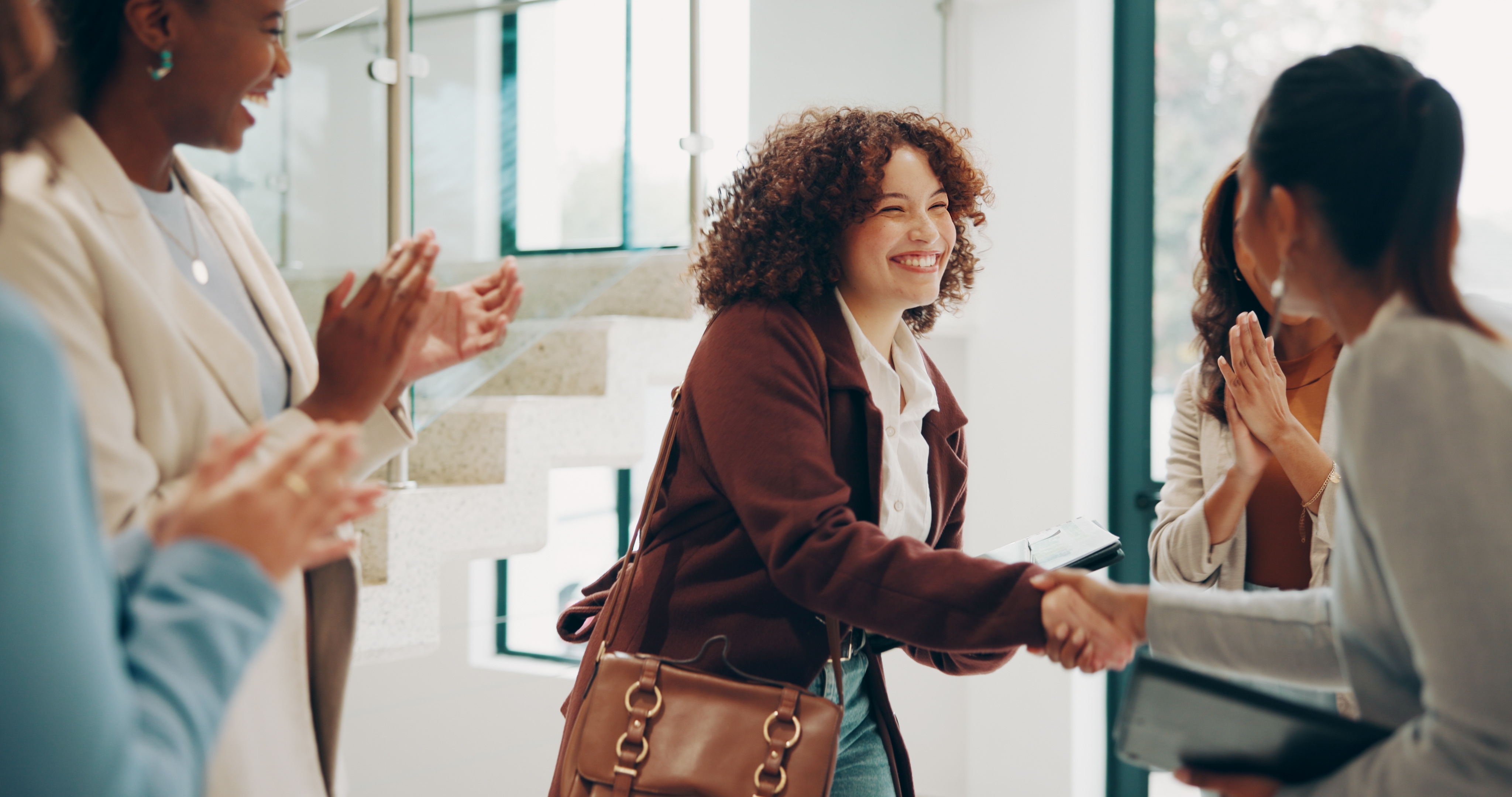 Happy women shaking hands with other women