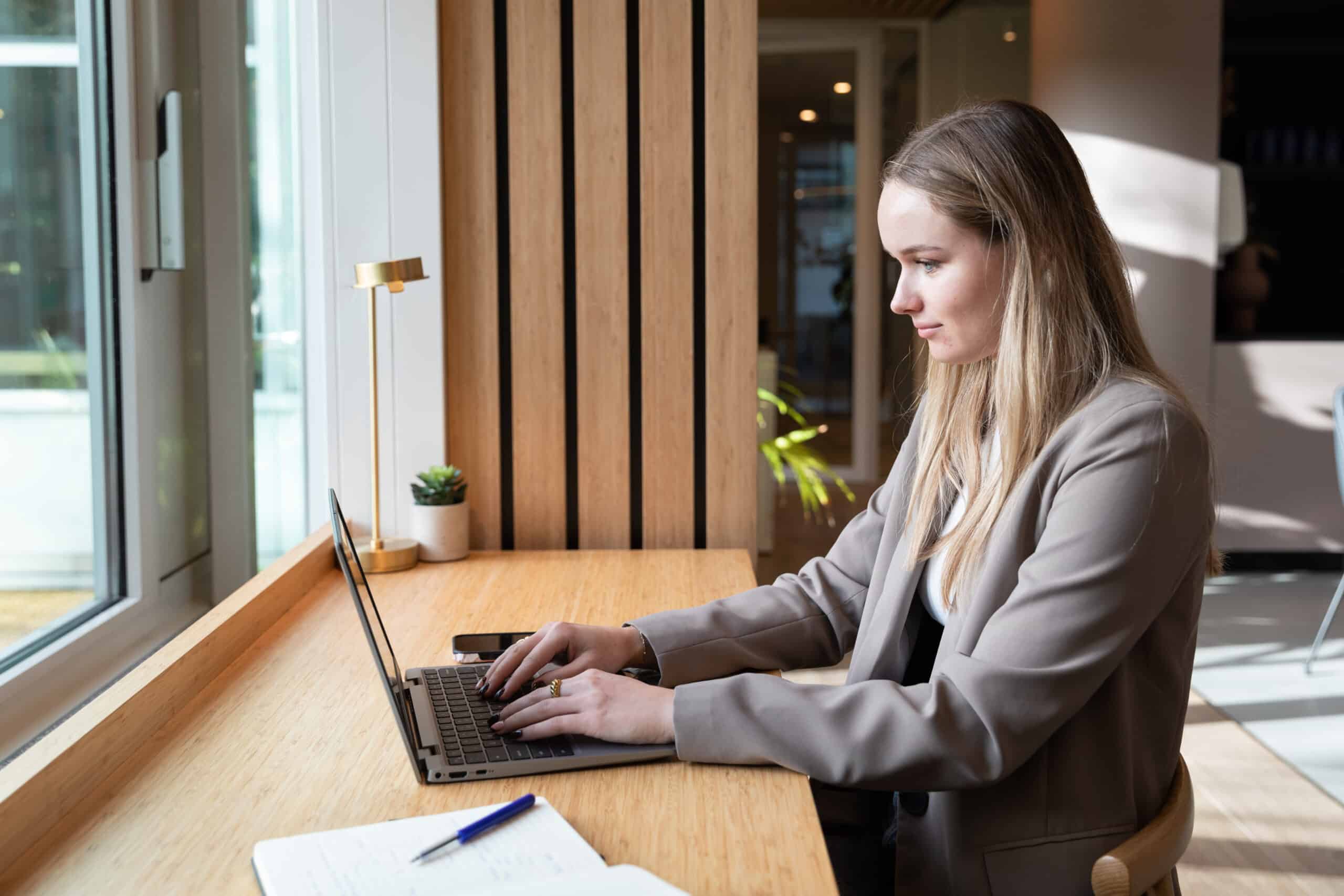Woman working on a laptop checking work permits