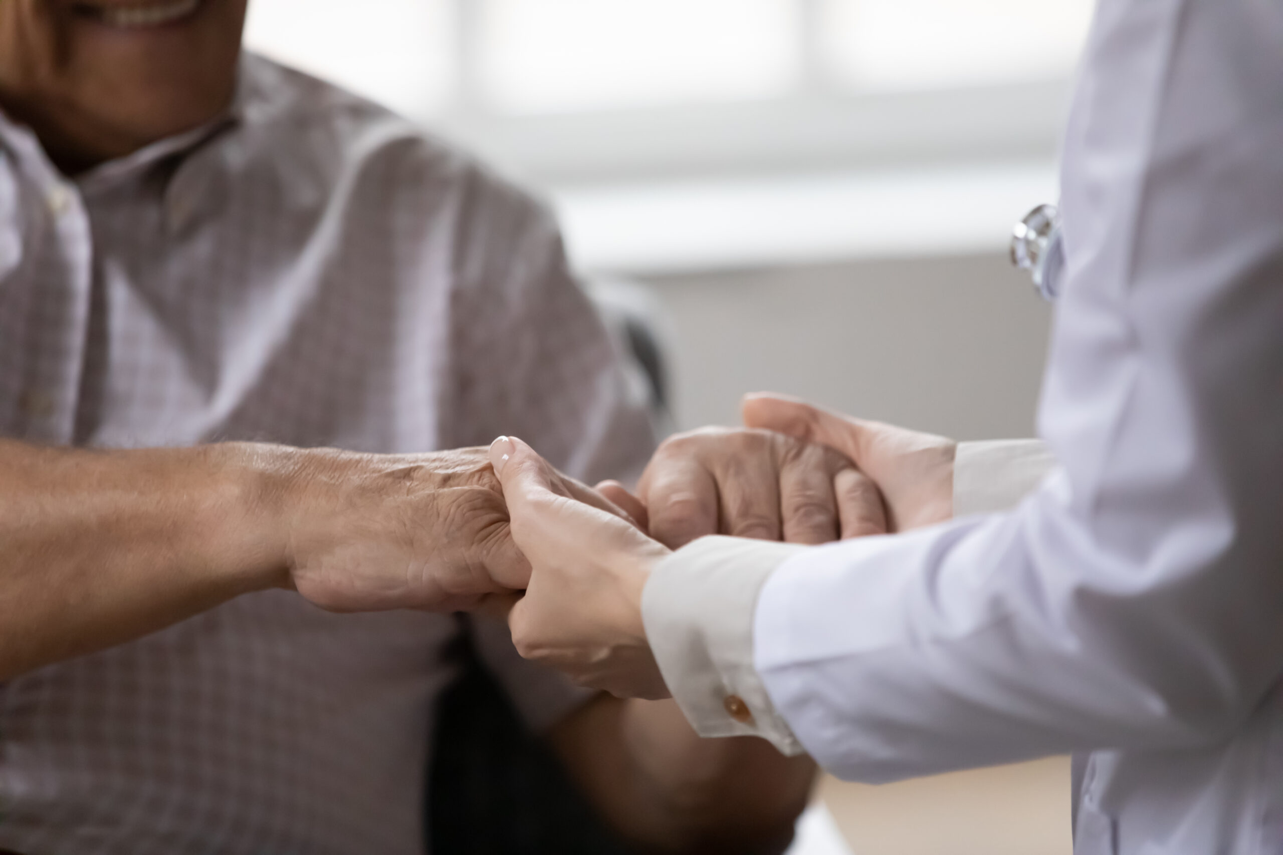 patient and doctor holding hands