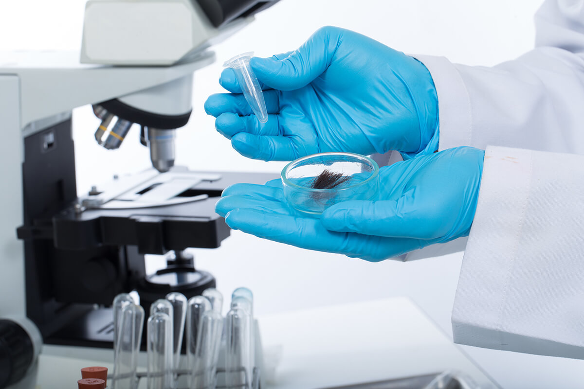 lab technician using a swab to collect oral fluid for testing
