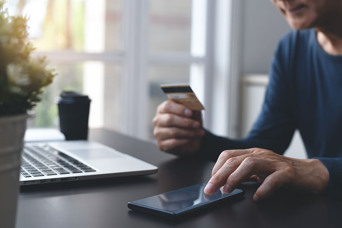 Working man laptop coffee checking credit card