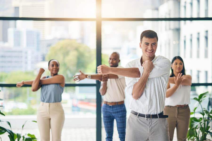 Workout, stretching and a group of business people in the office to exercise for health or mobility together