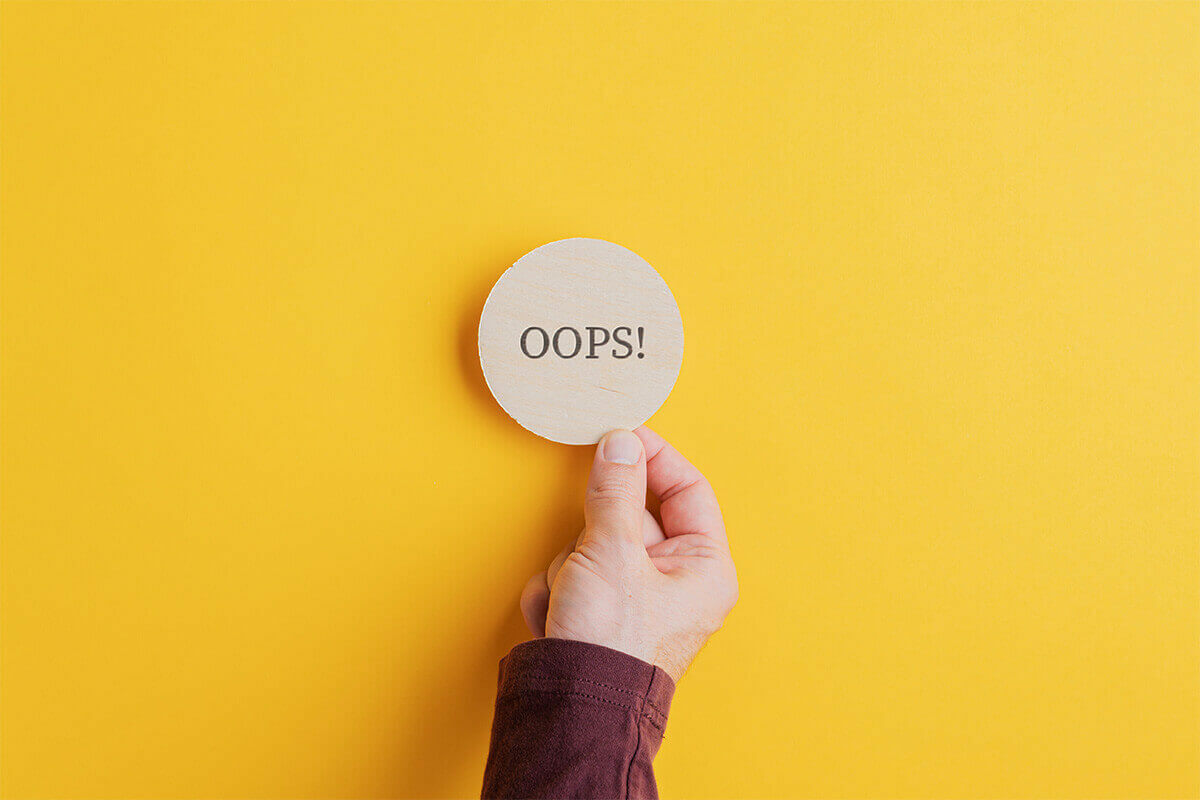hand picking up a circle with the word "oops"