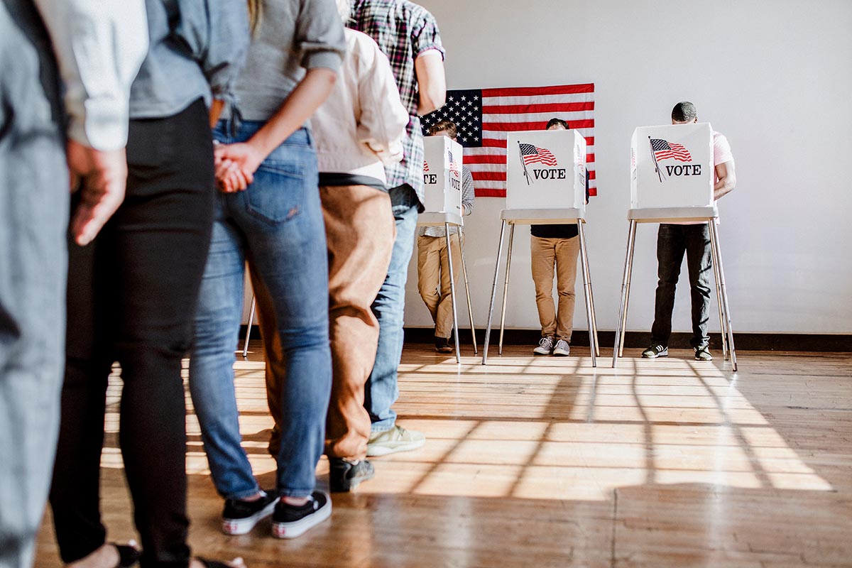 hand dropping a ballot into a ballot box