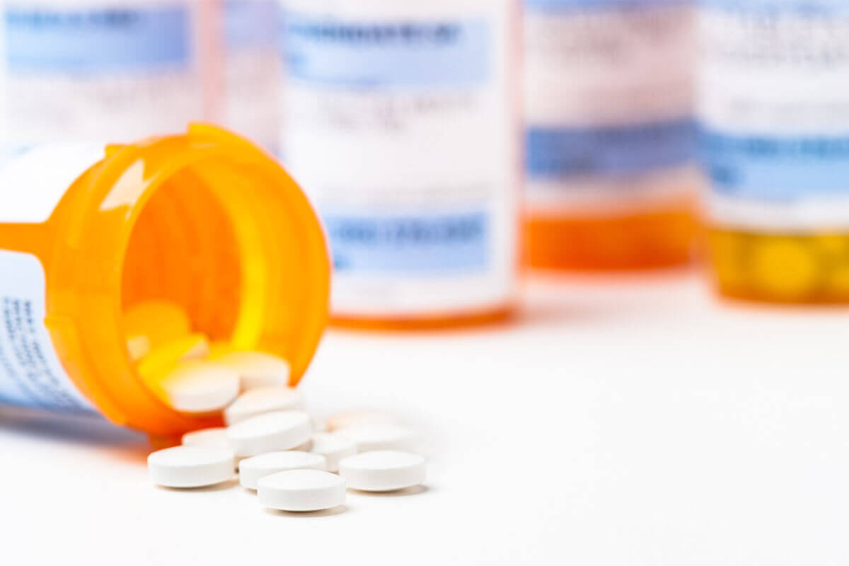 prescription drug bottles pills pouring onto counter