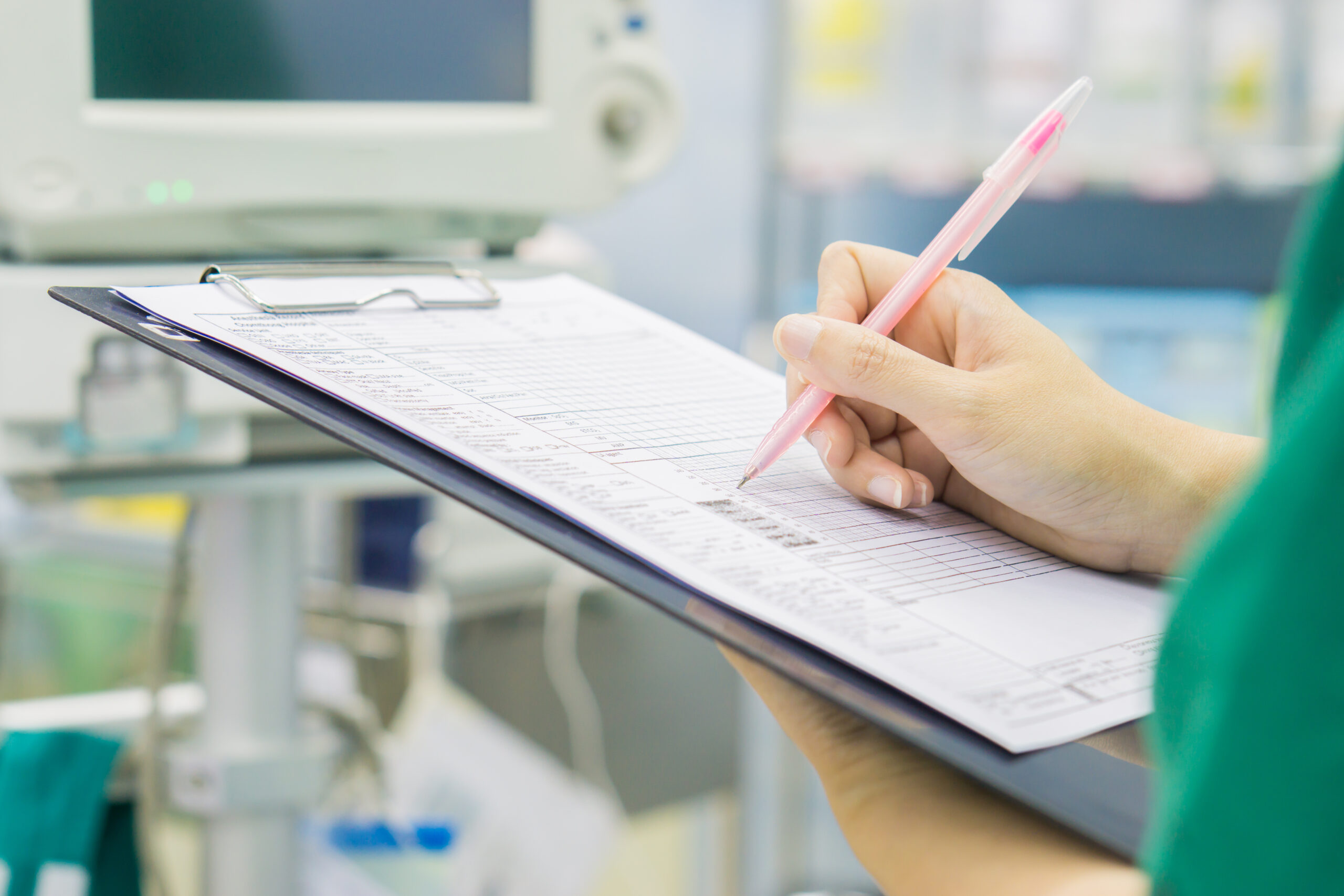 A care worker ticking something off on a clipboard.