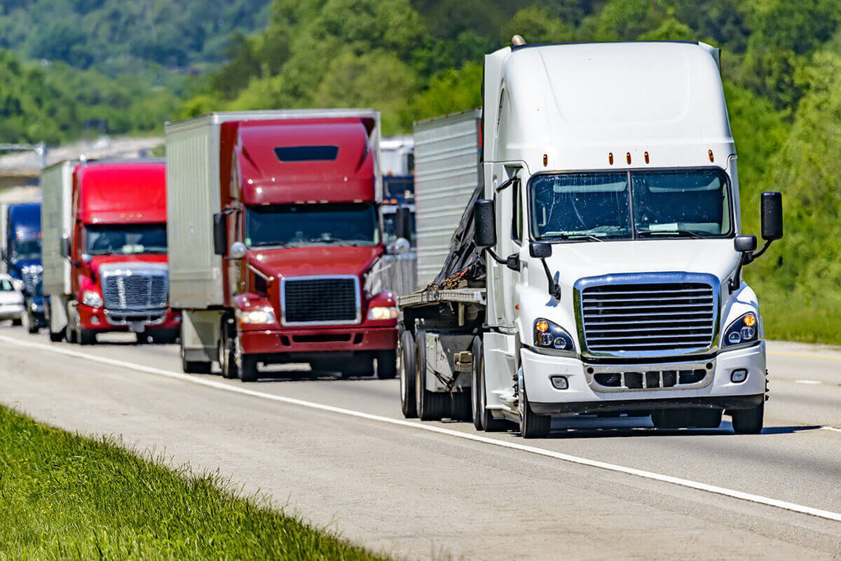 Several 18-wheelers driving on the road