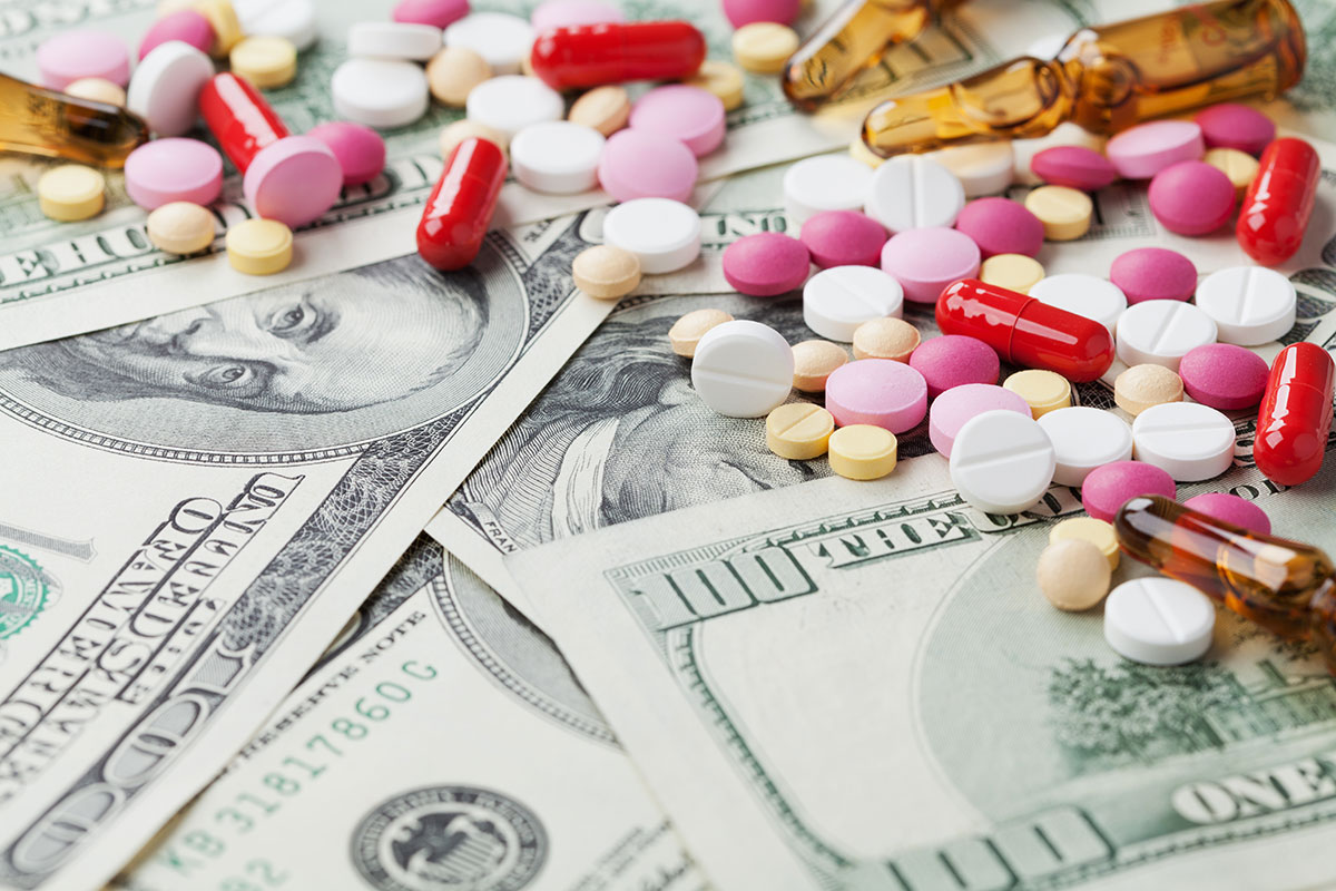Heap of pharmaceutical drug and medicine pills scattered on dollar cash money, cost of drug abuse concept