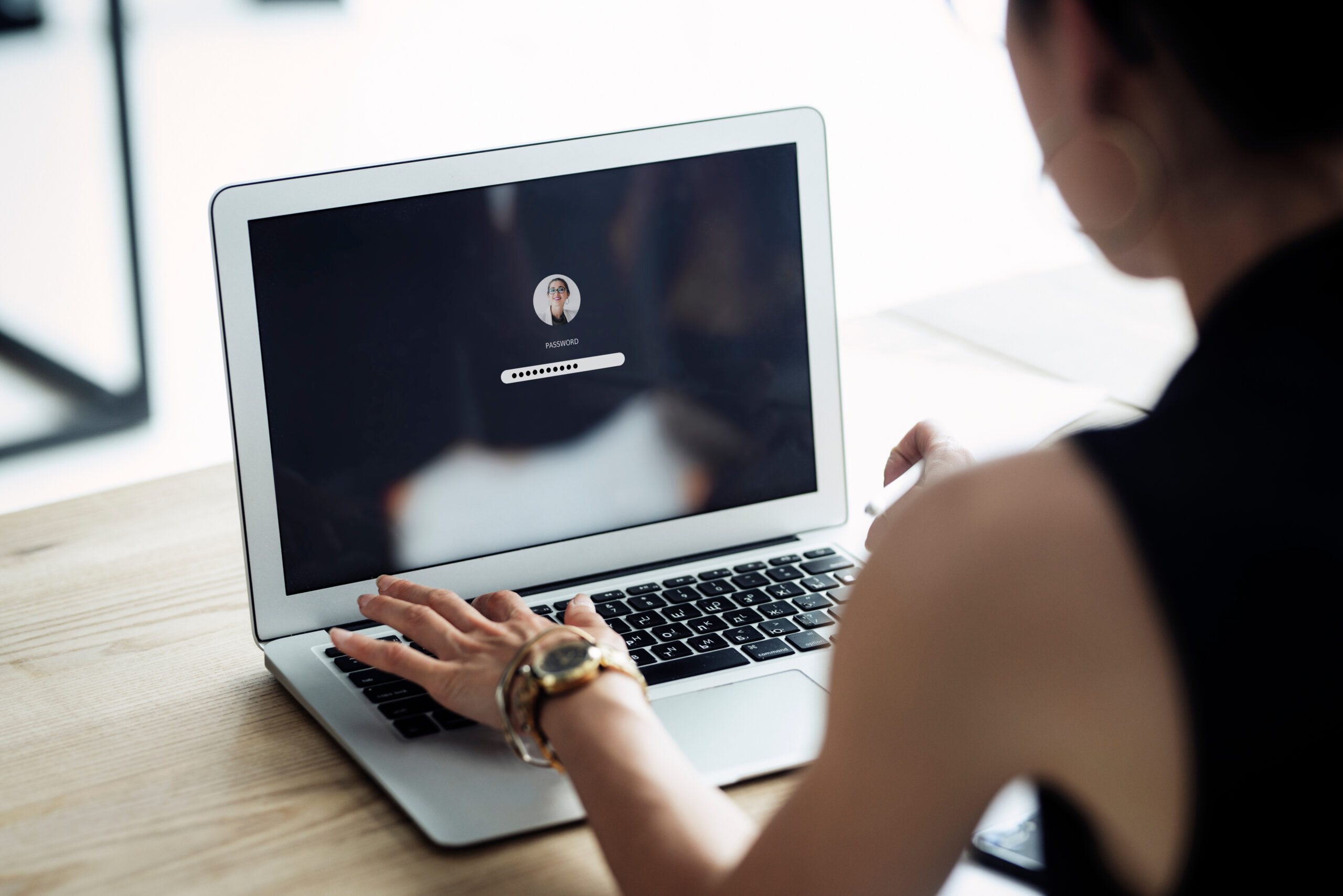 Woman writing her password on computer