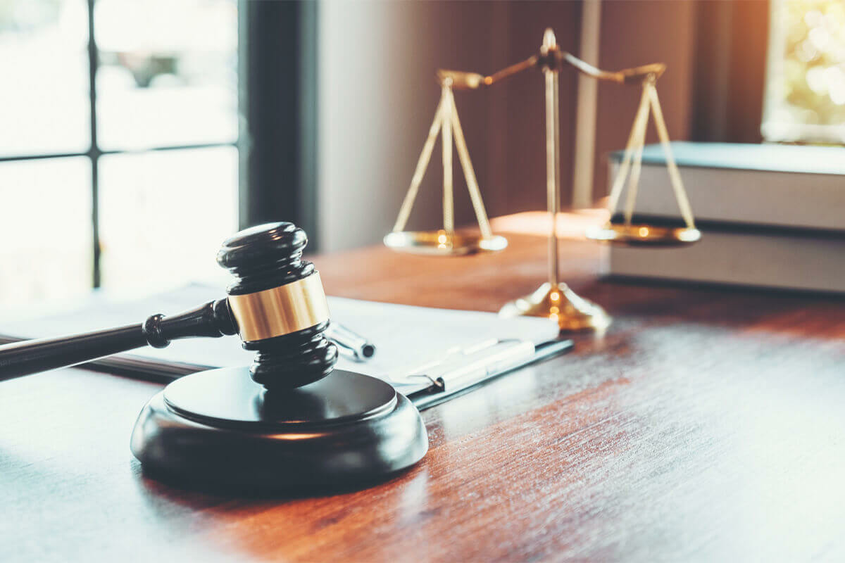 Gavel sitting on a desk with scales of justice