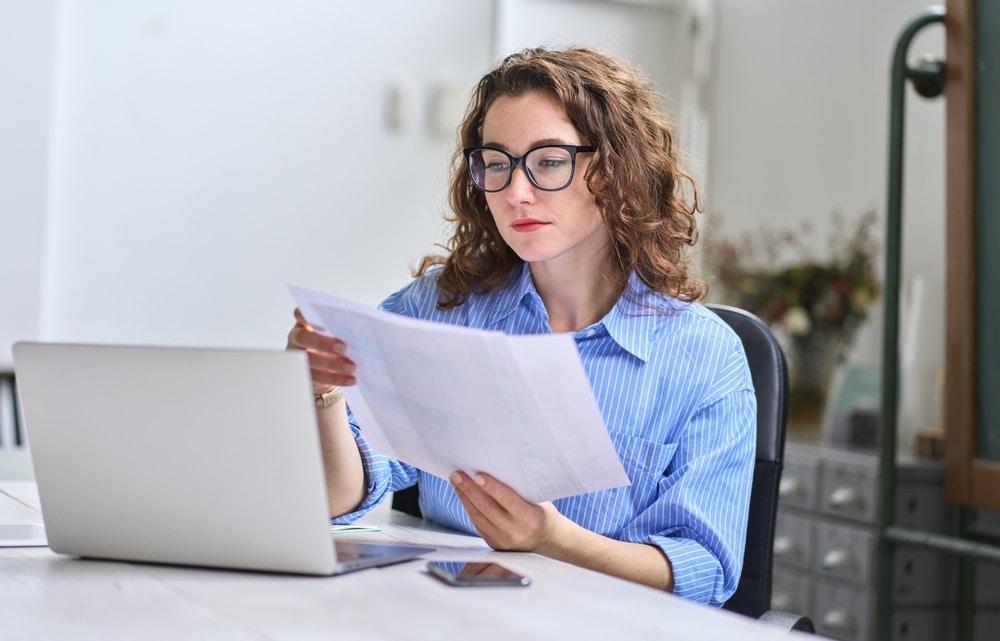 A woman at the workplace is reading about staff vetting regulations
